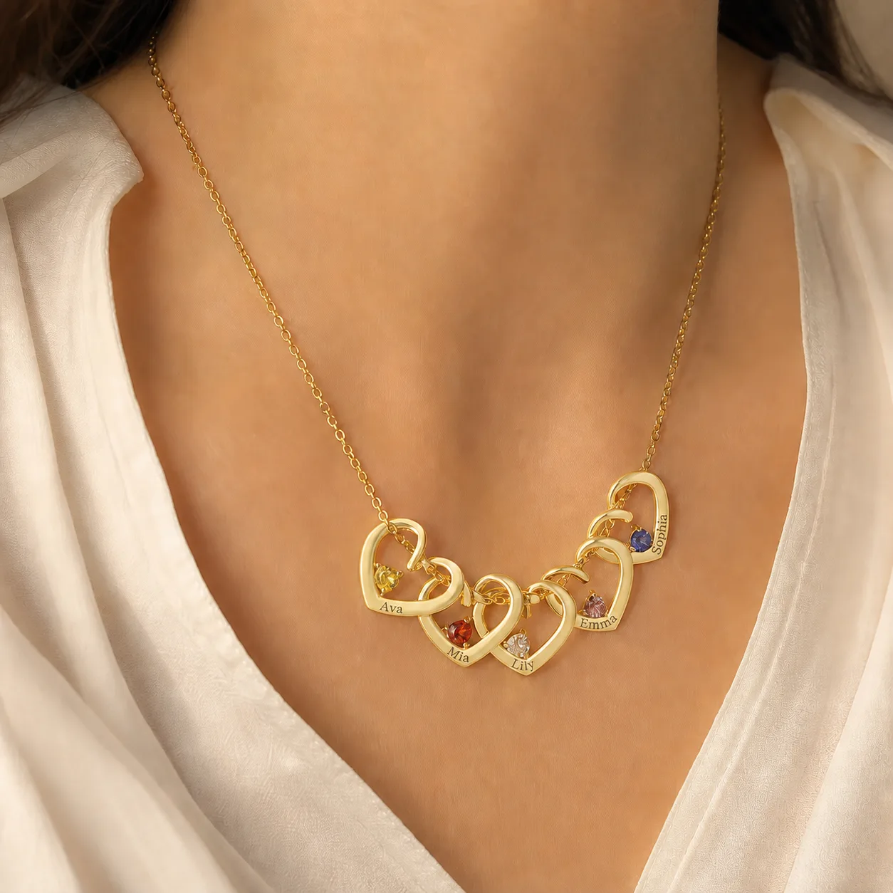 Five engraved family names on the gold heart necklace