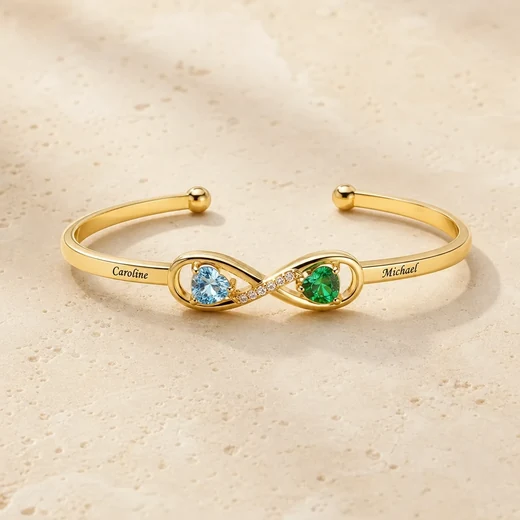 Gold tone open-heart cuff with two engraved names and two birthstones