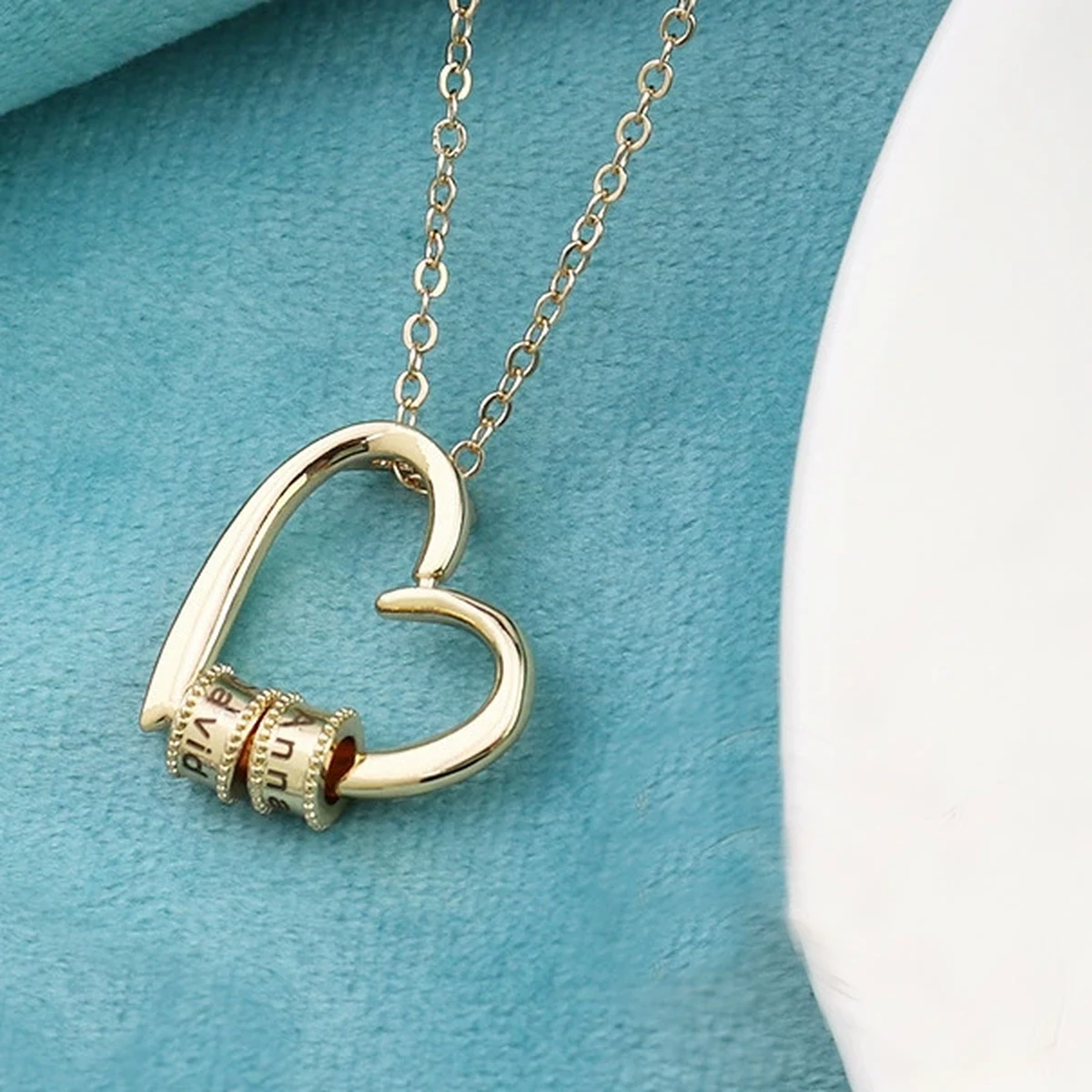 Engraved name beads and birthstone accents inside an open heart necklace