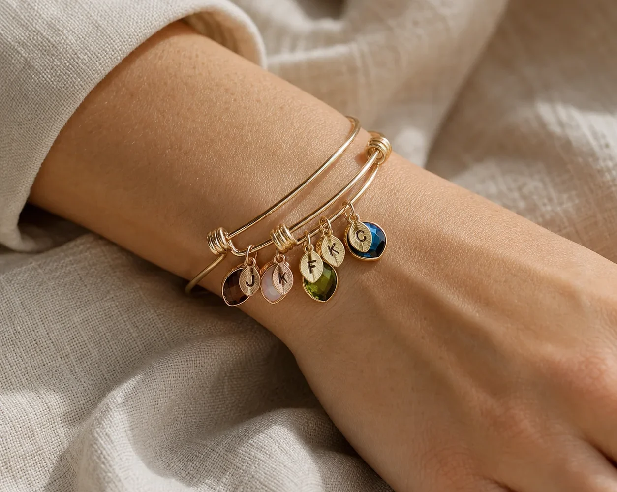 Family branch birthstone bangle with engraved leaf charms shown on a wrist