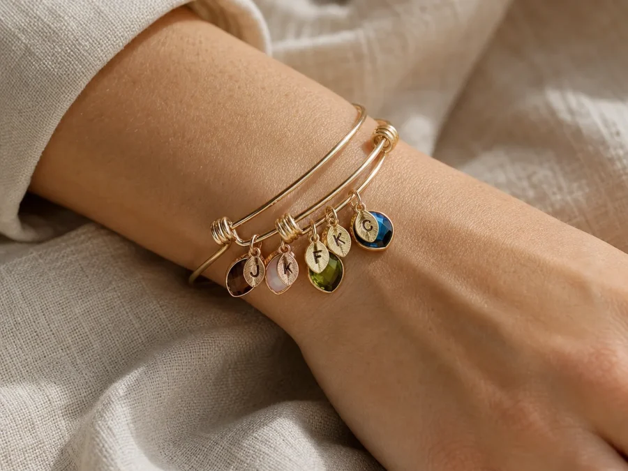 Family branch birthstone bangle with engraved leaf charms shown on a wrist