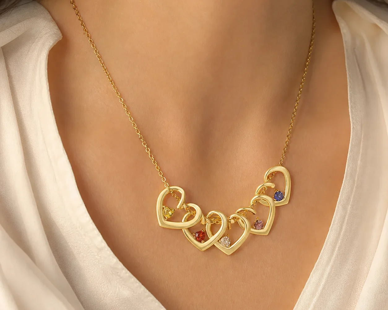 Gold-tone twisted heart birthstone necklace shown at everyday scale on a model