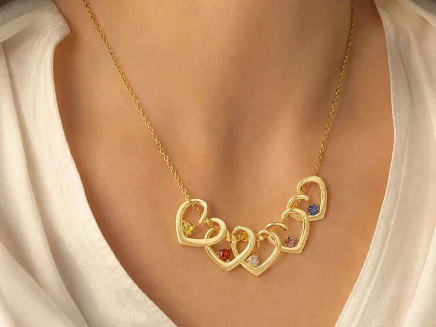 Gold-tone twisted heart birthstone necklace shown at everyday scale on a model