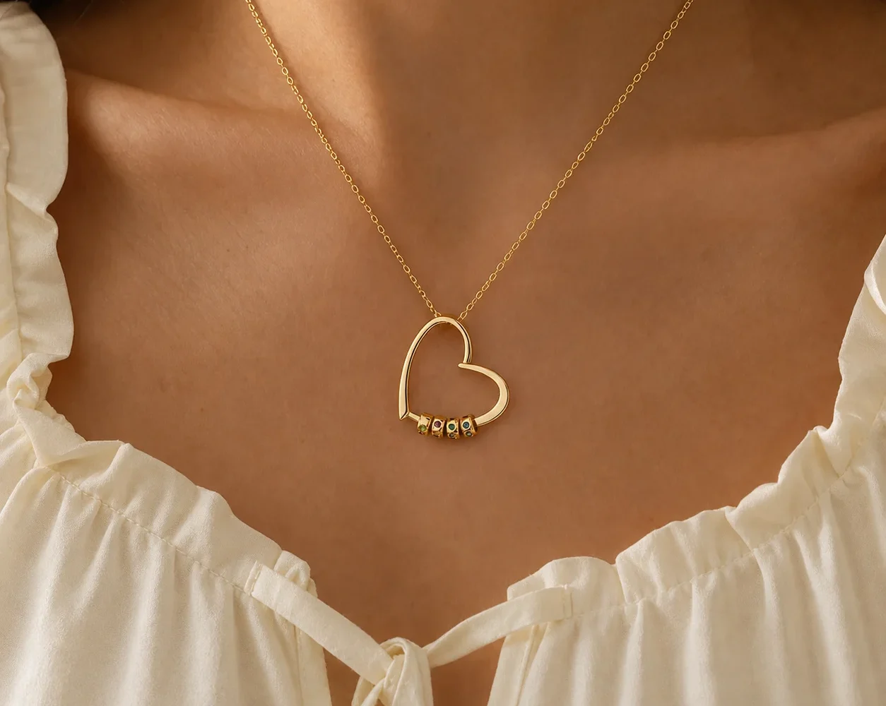 Gathered hearts name necklace with small engraved beads shown at everyday scale on a model