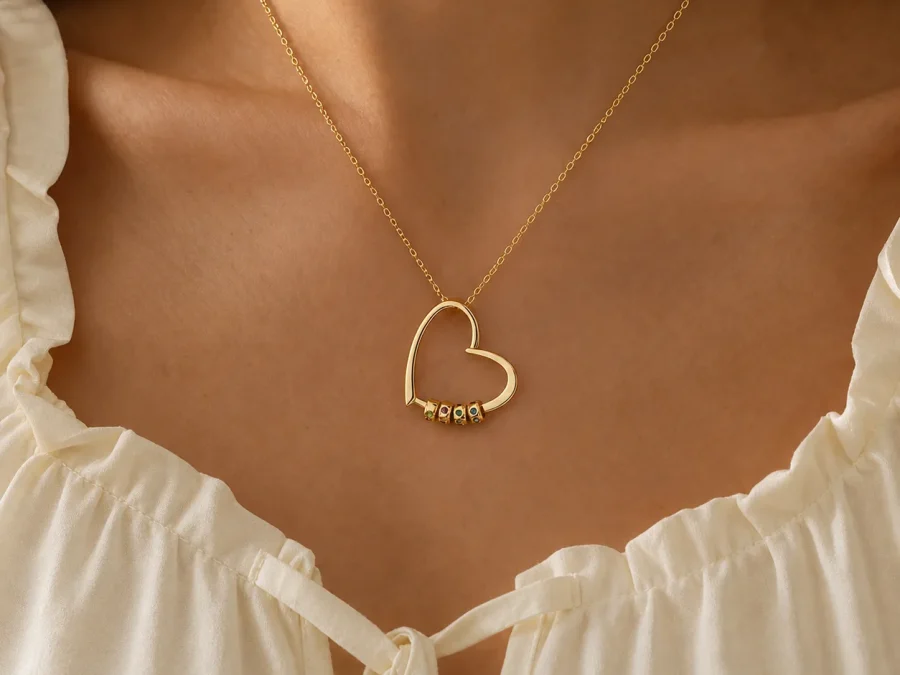 Gathered hearts name necklace with small engraved beads shown at everyday scale on a model