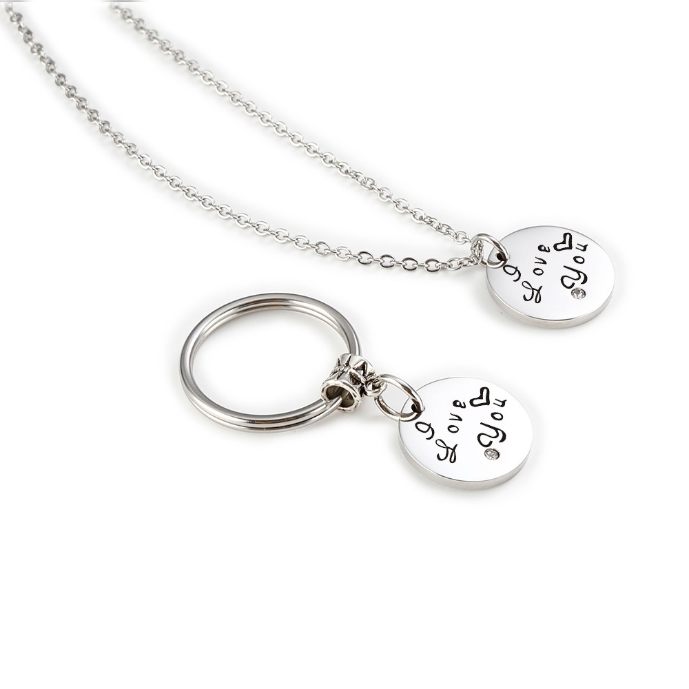 Stainless steel couple set with two engraved heart pendants, birthstones and a coil keychain
