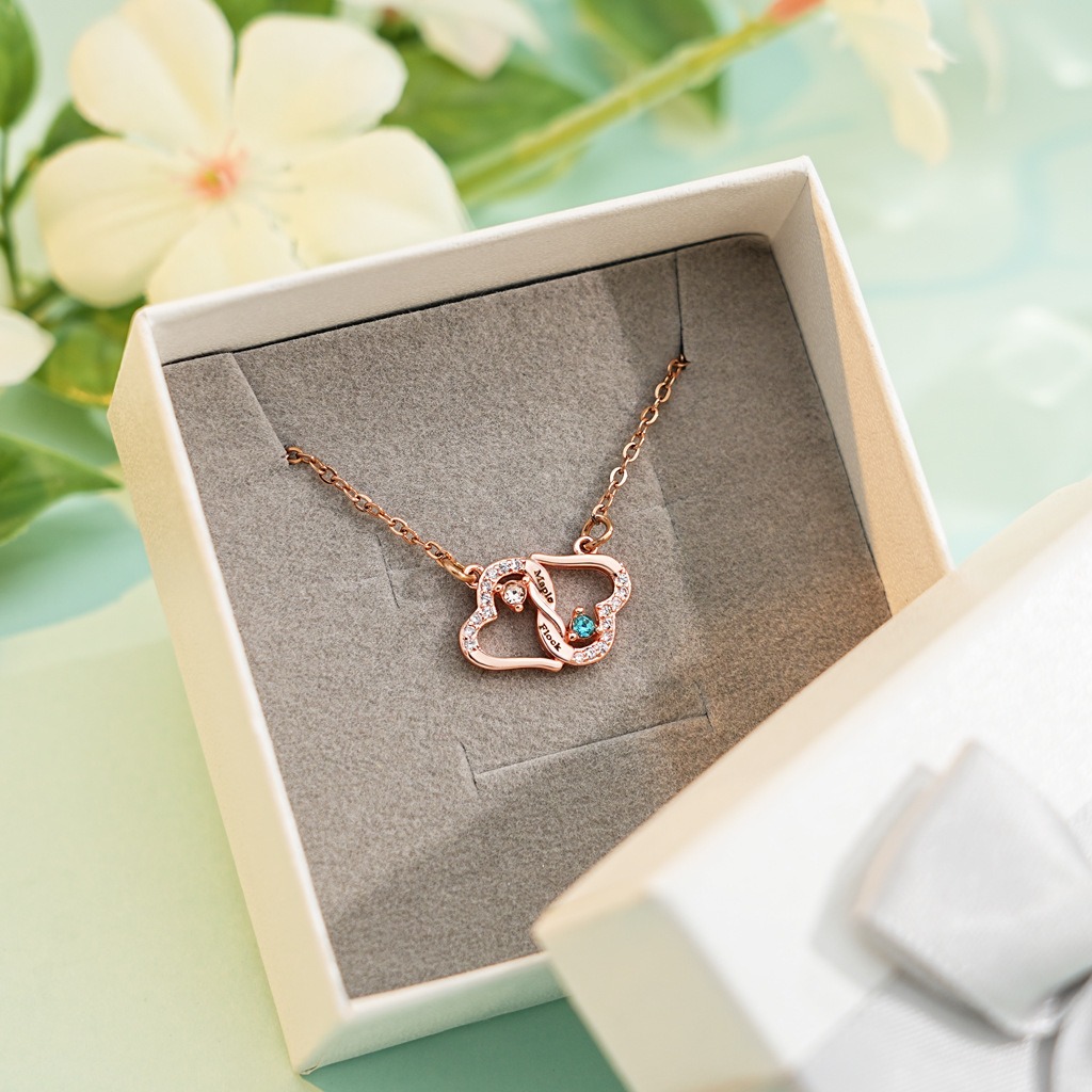 Two interlocking heart name necklace with a birthstone accent on a cross chain