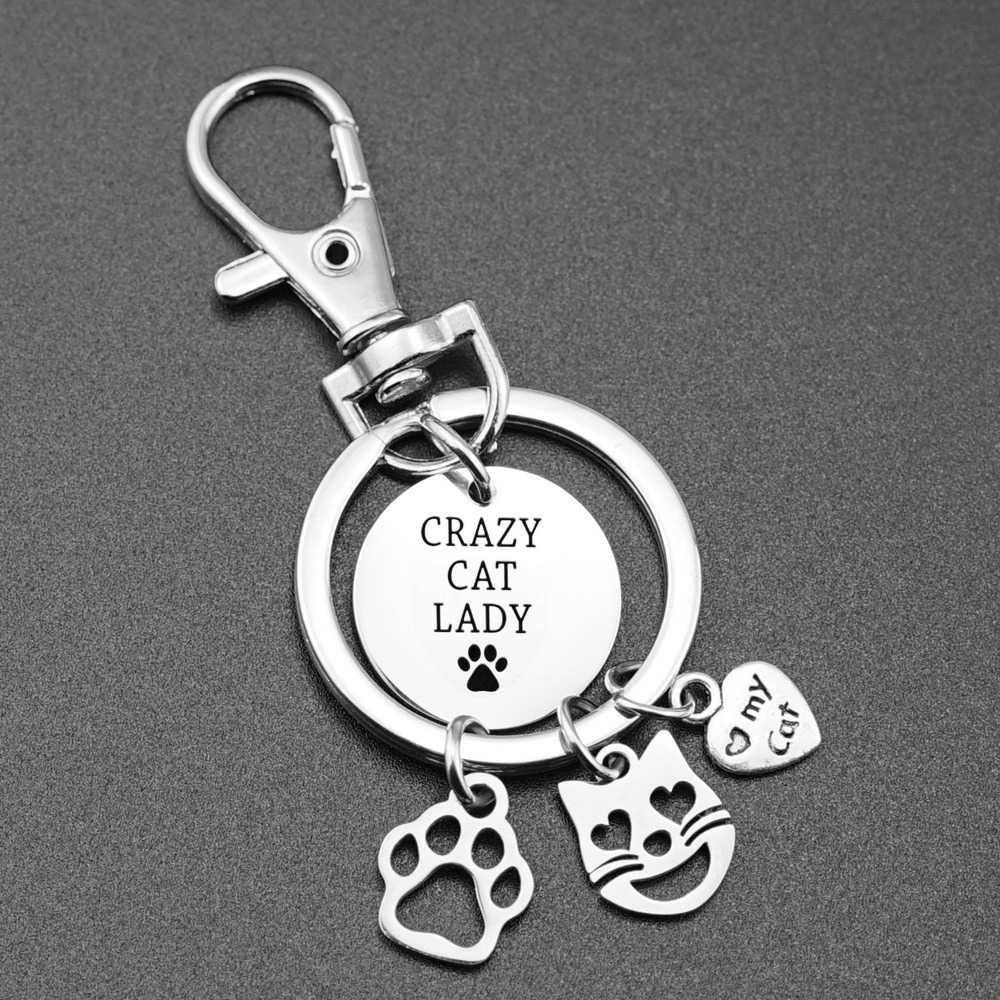 Stainless steel cat paw keychain with an engraved name and birthstone charm