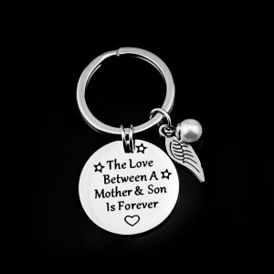 Round stainless steel keychain engraved with a name and finished with a wing and pearl accent plus a birthstone