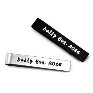 Slim stainless steel tie clip with one line of custom engraving and a small birthstone accent